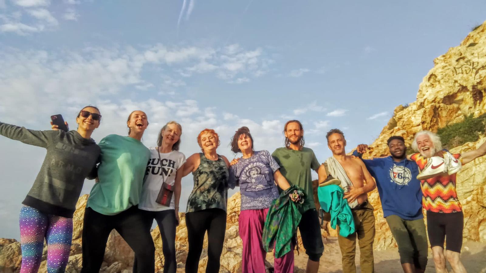 a group of smiling people standing on the beach